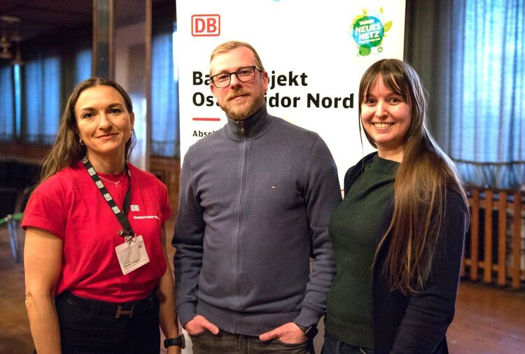 Gruppenbild zeigt 2 Frauen, 1 Mann vor einem Roll-up